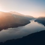 lake between trees and mountains